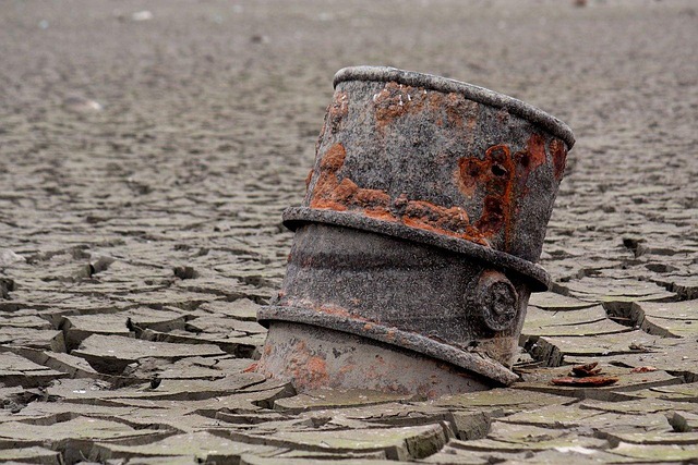 An old barrel embedded in the ground of a desert